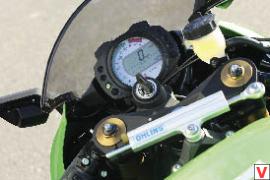 Компактные приборы «Кавы» соседствуют с рулевым демпфером Ohlins, призванным обезопасить быстрого «зеленого жеребца» от такого опасного явления, как воблинг. Но, в отличие от такого же «девайса» на Fireblade, он не электронный